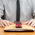 Man in a tie with a manila folder and red toy car